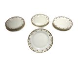 un lot de six assiettes plates blanches et dorées sur fond blanc
