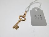 a gold key with a tag attached to it sitting on a table