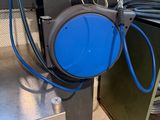 un tuyau bleu relié à un fût bleu posé sur une table