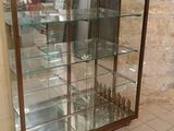une vitrine en verre dans le coin d'une pièce