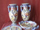deux vases et une assiette posés sur une nappe rouge