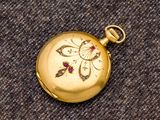 une montre de poche en or ornée d'un diamant rouge