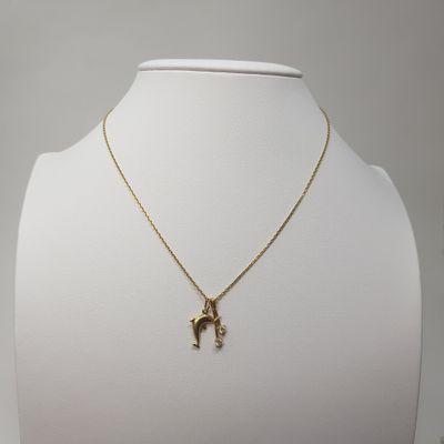 a gold plated necklace with a horse pendant on a mannequin