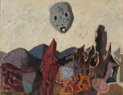une peinture représentant un masque sur un mur, au-dessus d'un tas de pierres