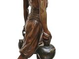 bronze statue of a man carrying a pot on a wooden base