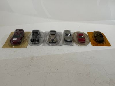 several toy cars are lined up in a row on a white surface