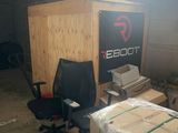 a room with a desk, chair, and boxes in it