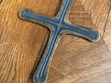an old metal cross on a wooden floor on a hard wood floor