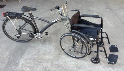 un vélo auquel est fixé un fauteuil roulant, garé dans un garage