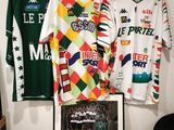 two shirts hanging on a wall next to a framed picture