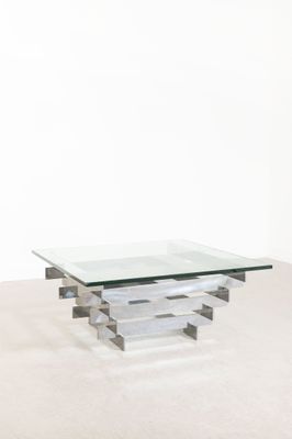 une table basse en verre et chrome avec un plateau carré en verre