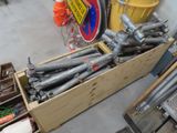 a wooden box filled with metal pipes and other items
