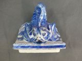 a blue and white ceramic sculpture of a dog and a cat