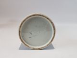 a white cup with a brown rim sitting on a white surface