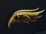 une image représentant une broche en or sertie de diamants sur un fond noir