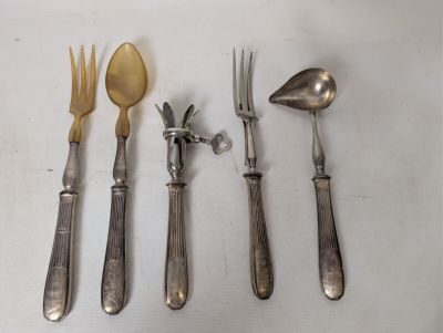 four forks, a spoon, and a knife on a table