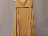 a yellow dress hanging on a hanger on a wall