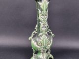 a green vase that is sitting on a table