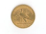 a gold coin with a bird on it on a white surface