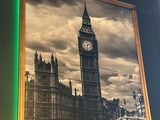 a picture hanging on the wall of a restaurant with a clock tower in the background