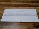 une boîte blanche sur laquelle est posé un clavier, posée sur une table en bois
