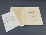 un gros plan d'un livre ouvert posé sur une table, avec une feuille de papier