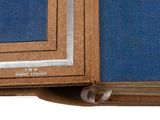 a brown book with a blue cover on a white table