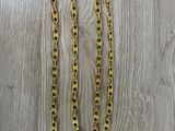 a gold chain necklace on a wooden surface