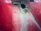 a red car that has a hole in the side of it