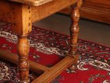 a wooden table on a red rug in a room