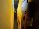 a yellow van that is parked next to a yellow wall
