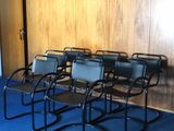 Plusieurs chaises sont alignées en rang dans une pièce vide.