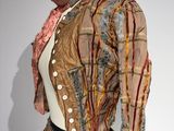 une photo d'une robe et d'une veste de femme exposées dans un musée