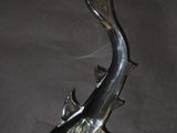statue of a fish on a rock with a fish fin sticking out of it ' s mouth