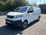 la petite camionnette blanche est garée dans le parking