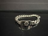 bracelet en argent orné d'un crâne et d'une croix sur un fond noir