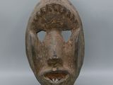 une image d'un masque en bois sur un support