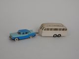 une petite voiture et un petit bus sur une surface blanche