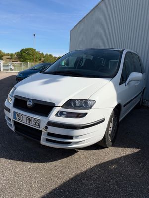 la photo d'une voiture blanche garée devant un bâtiment