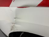 a red and white stripe on the side of a white car