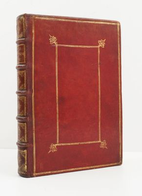 un vieux livre en cuir rouge, avec des bordures dorées et une encadrement doré