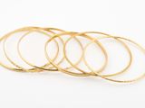 un lot de cinq bracelets en or sur fond blanc
