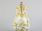 a white vase with a yellow and green design on it