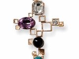 a close up of a cross with a bunch of stones on it