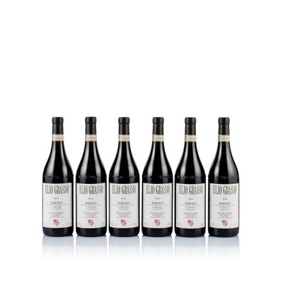 four bottles of red wine lined up on a white surface