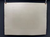 une feuille blanche accrochée au mur à l'aide d'une ficelle
