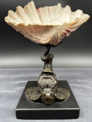 un gros plan d'une sculpture représentant un coquillage posée sur un socle