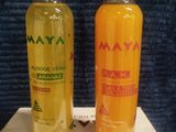 two bottles of orange juice sitting on top of a white box