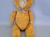 un ours en peluche marron avec un nœud bleu autour du cou