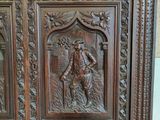 carvings of a man and a woman on a wooden cabinet